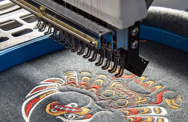 Multi-head embroidery machine stitching a custom design