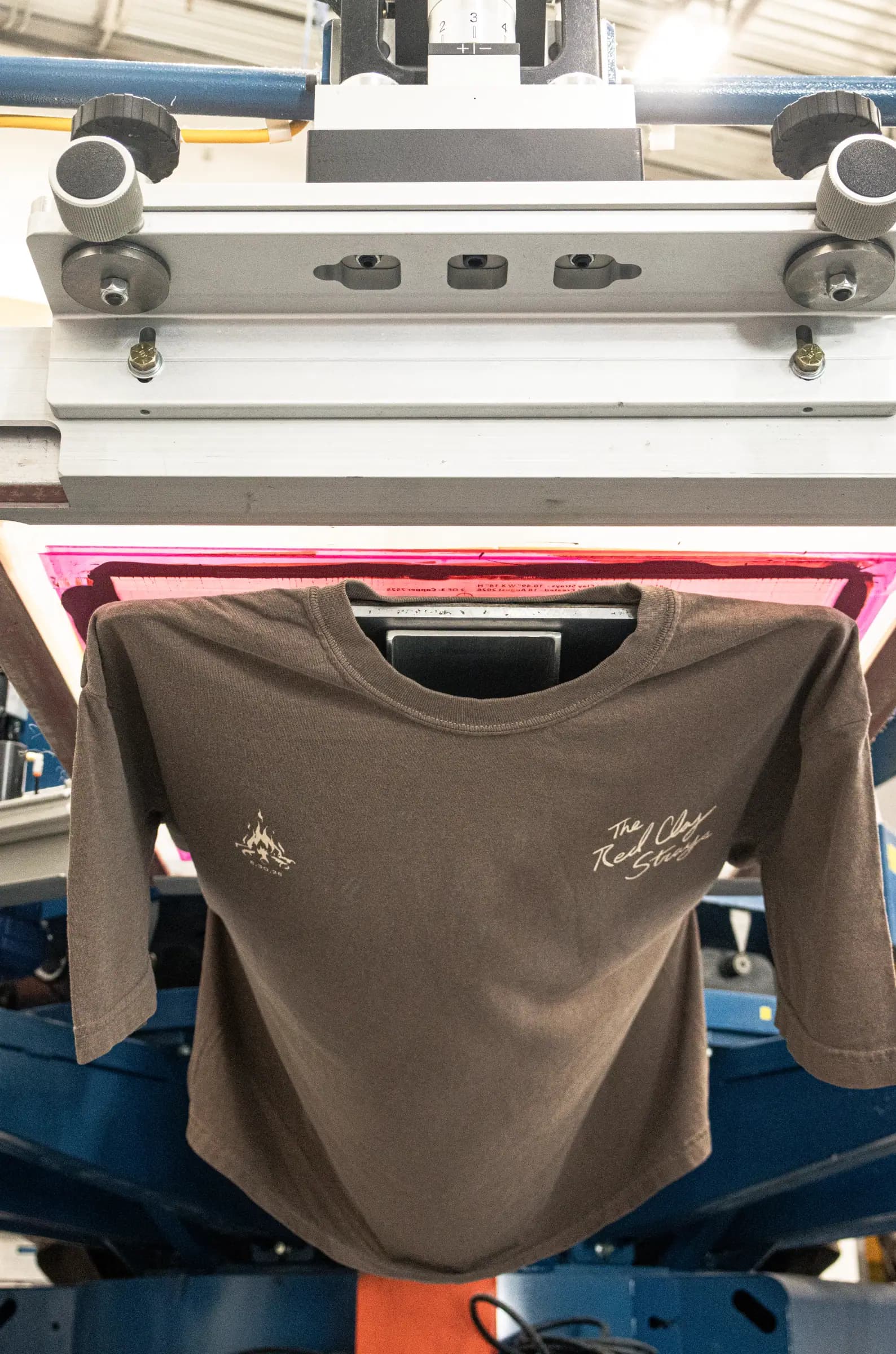 A brown shirt on the press with two small chest prints